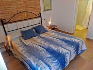 a bed with a blue comforter in a bedroom at Piso recién reformado con gran terraza in Xeraco