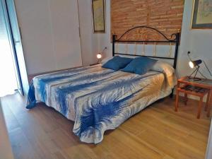 a bedroom with a large bed with a blue comforter at Piso recién reformado con gran terraza in Xeraco