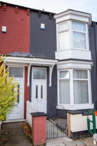 a black and white house with a white door at Alphalink Apartment in Middlesbrough