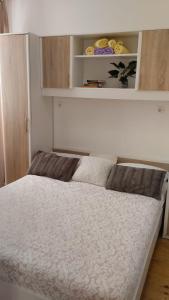 a white bed in a room with a shelf at Apartment Josipa in Dubrovnik