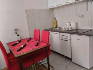 a small kitchen with a red table and red chairs at Apartment Josipa in Dubrovnik