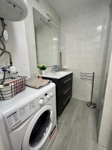 y baño con lavabo y lavadora. en Acogedor loft en recinto privado - Terapia Salada, en Estepona