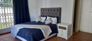 1 dormitorio con 1 cama con edredón azul y ventana en Home Sweet Home en Deneysville
