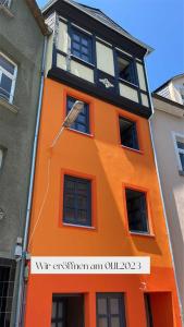 un bâtiment orange avec un panneau devant lui dans l'établissement Burghaus-Cochem, à Cochem