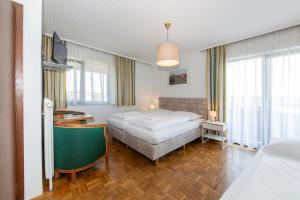 a hotel room with a bed and a desk at Tirolerhof in Sankt Georgen im Attergau