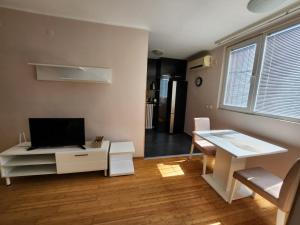 a living room with a tv and a table and a desk at Morning Wood - Panorama in Belgrade