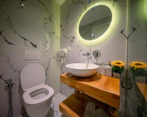 サランダにあるHotel Olsiのバスルーム(洗面台、トイレ、鏡付)