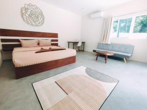 una camera con letto, divano e tavolo di Villa Baan Naí Pã a Baan Tai