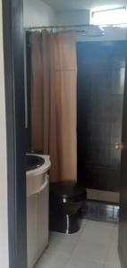 a bathroom with a black toilet and a sink at Casas campestre en un lugar encantador a las faldas del Taita Imbabura 