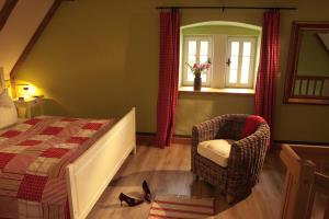 1 dormitorio con 1 cama, 1 silla y 1 ventana en SPA-Resort Landlust in Dresden en Dresden