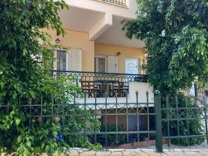 a house with a balcony with tables and chairs at ARETI4 in Petalidi
