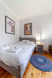 a bedroom with a large bed and a wooden floor at Stylish 1 BDR apt wcommunal garden, Greenwich in London