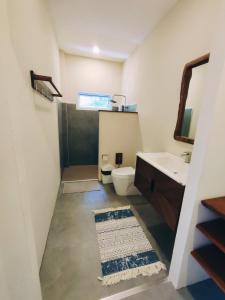 a bathroom with a sink and a toilet and a mirror at Villa Baan Naí Pã in Ban Tai