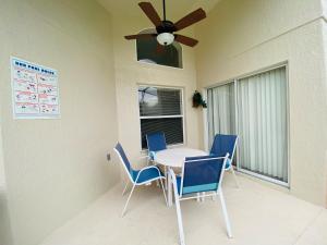 mesa de comedor con sillas y ventilador de techo en Ezras Vacation Home at Southern Dunes, en Haines City
