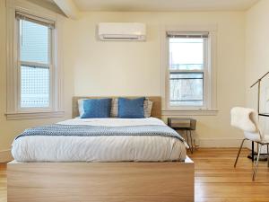 una camera da letto con un grande letto con cuscini blu di 4 Bedroom Condo At Harvard Square and Harvard University a Cambridge