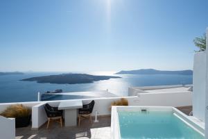 una villa con tavolo e piscina di Asha Luxury Suites a Firà