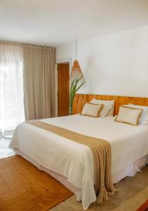 a large white bed in a room with a window at Quadrado Pousada in São Miguel dos Milagres