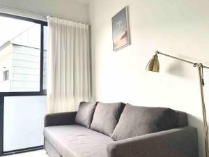 - un salon avec un canapé et une fenêtre dans l'établissement Centralize Stylish Loft Apartment Near MRT 市中心全景屋, à Singapour