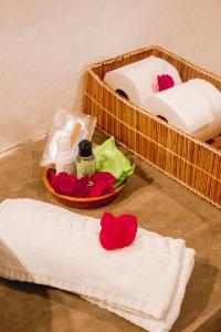 a bathroom with towels and flowers on the floor at Quadrado Pousada in São Miguel dos Milagres