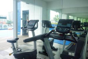 a gym with three treadmills in front of a mirror at Centralize Stylish Loft Apartment Near MRT 市中心全景屋 in Singapore