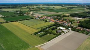 une vue aérienne sur un champ planté de maisons et d'arbres dans l'établissement Bed & Breakfast Carpe Diem Zeeland, à Serooskerke