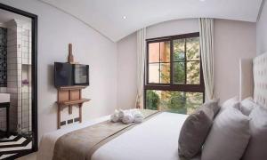 a bedroom with a bed with a tv and a window at Venetiean Condo Pattaya by LJB719 in Jomtien Beach +12 photos