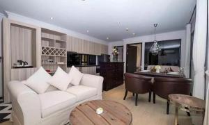 a living room with a white couch and a table at Venetiean Condo Pattaya by LJB719 in Jomtien Beach