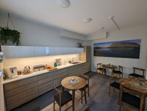 eine Küche mit 2 Tischen, einer Spüle und einer Theke in der Unterkunft The Ísafjörður Inn in Ísafjörður