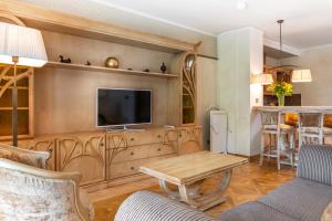 a living room with a tv and a table at Grand SPA Lietuva Serviced Apartments Dzūkija in Druskininkai