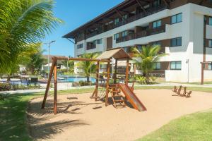 un parque infantil en la arena frente a un edificio en Flat 2 quartos em Porto, Cupe Beach Living (pé na areia)., en Porto de Galinhas