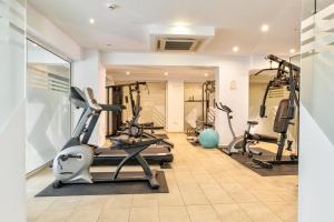 a gym with treadmills and ellipticals in a room at White Olive Premium Laganas in Laganas