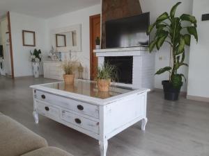 una mesa de centro blanca en la sala de estar con chimenea en Casa con gran jardín y unas preciosas vistas, en Teià