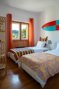 a bedroom with two beds and a window at Moby Dick Lodge Colares in Colares