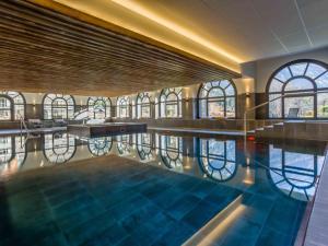 a swimming pool in a building with windows at Chamonix Praz Vue Mt Blanc Piscine in Chamonix-Mont-Blanc