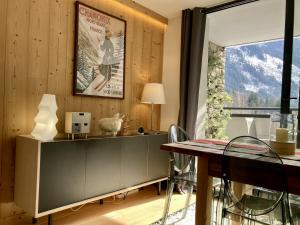 a dining room with a table and a window at Chamonix Praz Vue Mt Blanc Piscine in Chamonix-Mont-Blanc