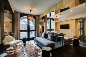 een woonkamer met een bank en een tv bij Chamonix Praz Vue Mt Blanc Piscine in Chamonix-Mont-Blanc
