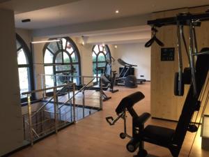 a gym with treadmills and machines in a room with windows at Chamonix Praz Vue Mt Blanc Piscine in Chamonix-Mont-Blanc