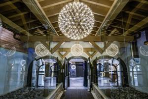 a hallway in a building with large chandeliers at Chamonix Praz Vue Mt Blanc Piscine in Chamonix-Mont-Blanc