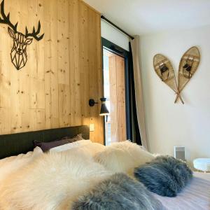 a bedroom with a bed with furry pillows on it at Chamonix Praz Vue Mt Blanc Piscine in Chamonix-Mont-Blanc