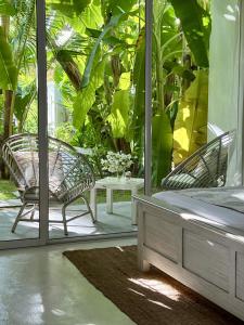 Pokój z 2 krzesłami i łóżkiem na patio w obiekcie Fairytale Inn w mieście Thoddoo