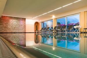 a swimming pool with chairs in a hotel at Appartment Thumerhof Wildschönau in Niederau