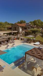 a large swimming pool with chairs and umbrellas at Country House L'Aia - Wellness & Relax in Casal Velino