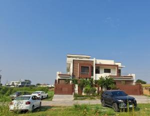 una casa con dos coches estacionados frente a ella en AIRWAYS B&B Islamabad Free Airport Pick and Drop en Islamabad