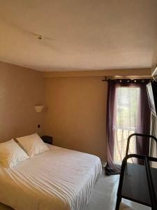 a bedroom with a white bed and a window at Hotel & Restaurant Le Mejean - Parc des Expositions in Lattes