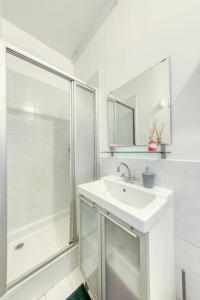 bagno bianco con lavandino e doccia di T2 La Défense avec Parking privé a Courbevoie