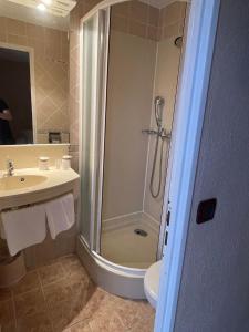 La salle de bains est pourvue d'une douche et d'un lavabo. dans l'établissement Hotel & Restaurant Le Mejean - Parc des Expositions, à Lattes