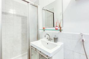 bagno bianco con lavandino e doccia di T2 La Défense avec Parking privé a Courbevoie