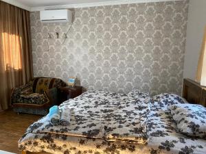 una camera da letto con un letto e una sedia di Aloha House a Akhaltsikhe