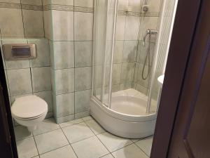 a bathroom with a shower and a toilet and a sink at Hostel Bialoleka - Darmowy parking, szybkie Wifi! in Warsaw