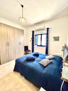 Un dormitorio con una gran cama azul con almohadas. en Casa Vacanze Longo, en Santa Marina Salina